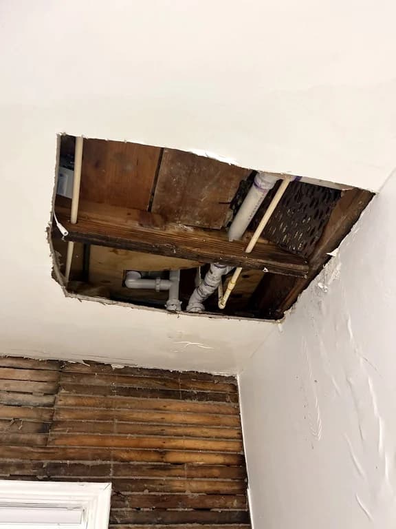 Water damage opened up through a ceiling cavity after a burst pipe