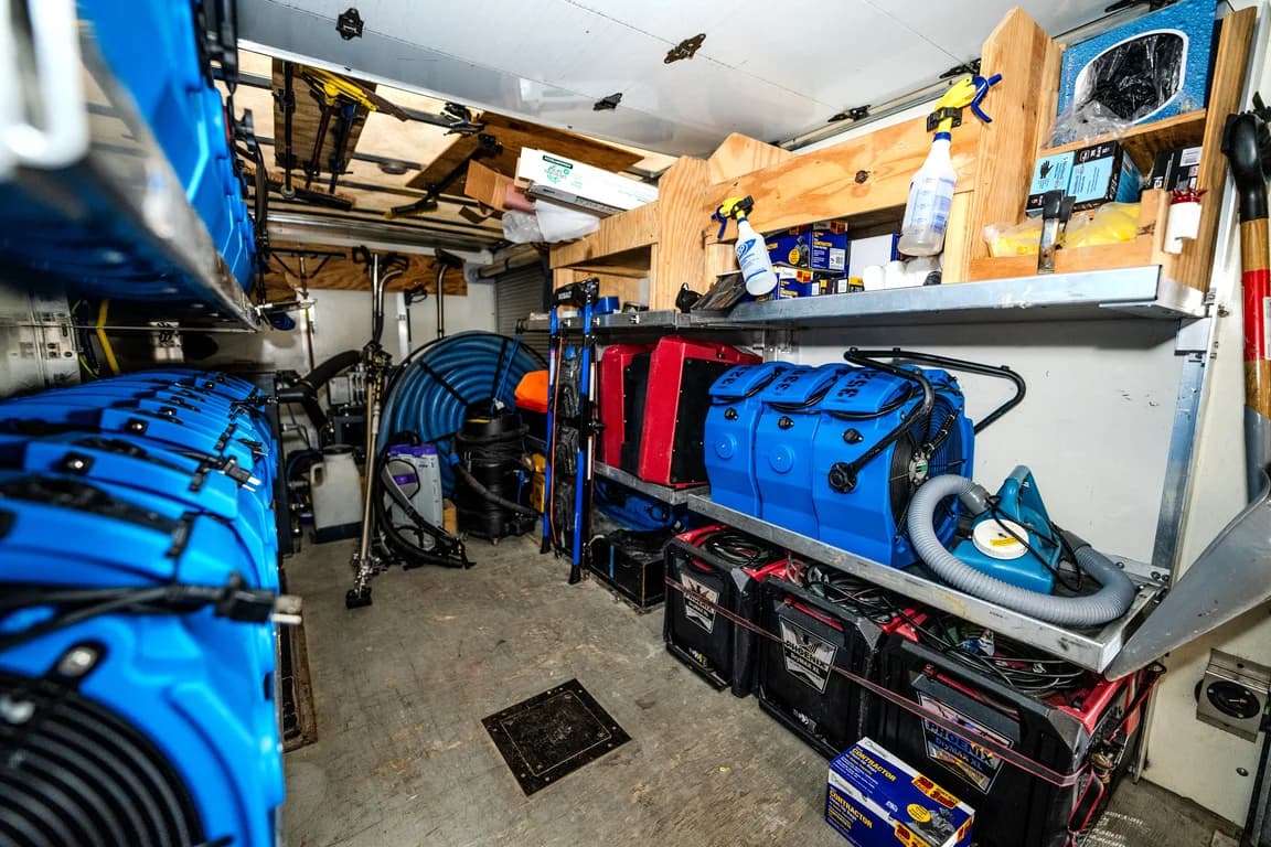 Air movers, hoses and cleanup supplies stored inside a restoration van