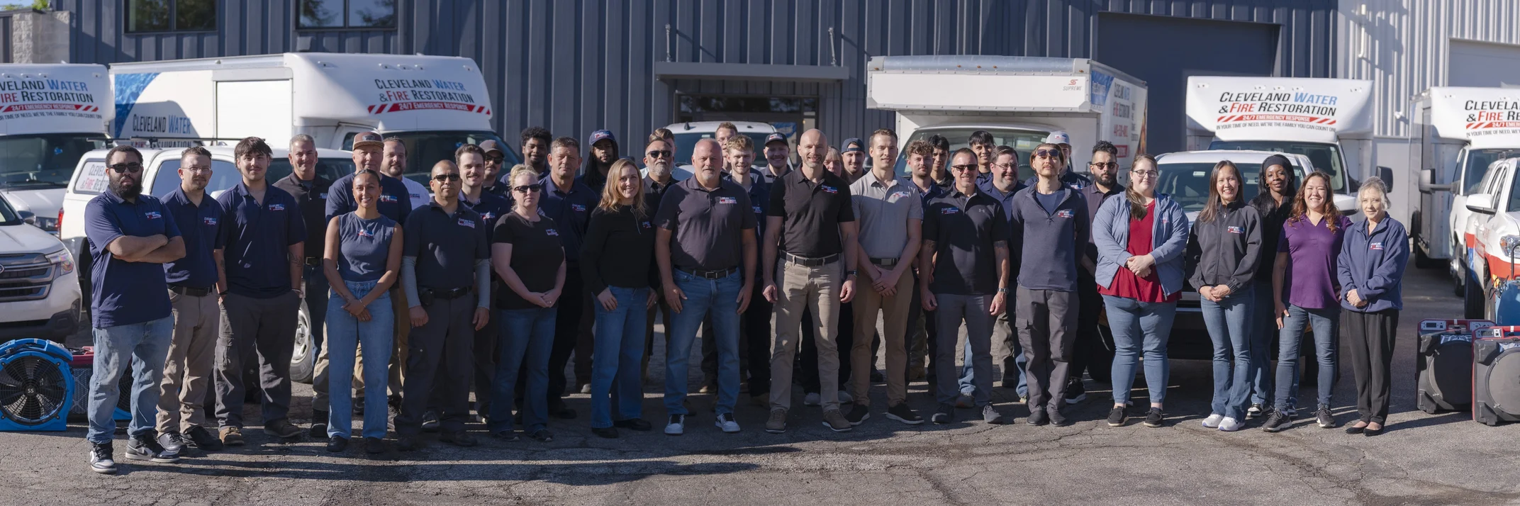 The Cleveland Water and Fire Restoration, Inc. team standing together in front of the response fleet outside the Solon facility